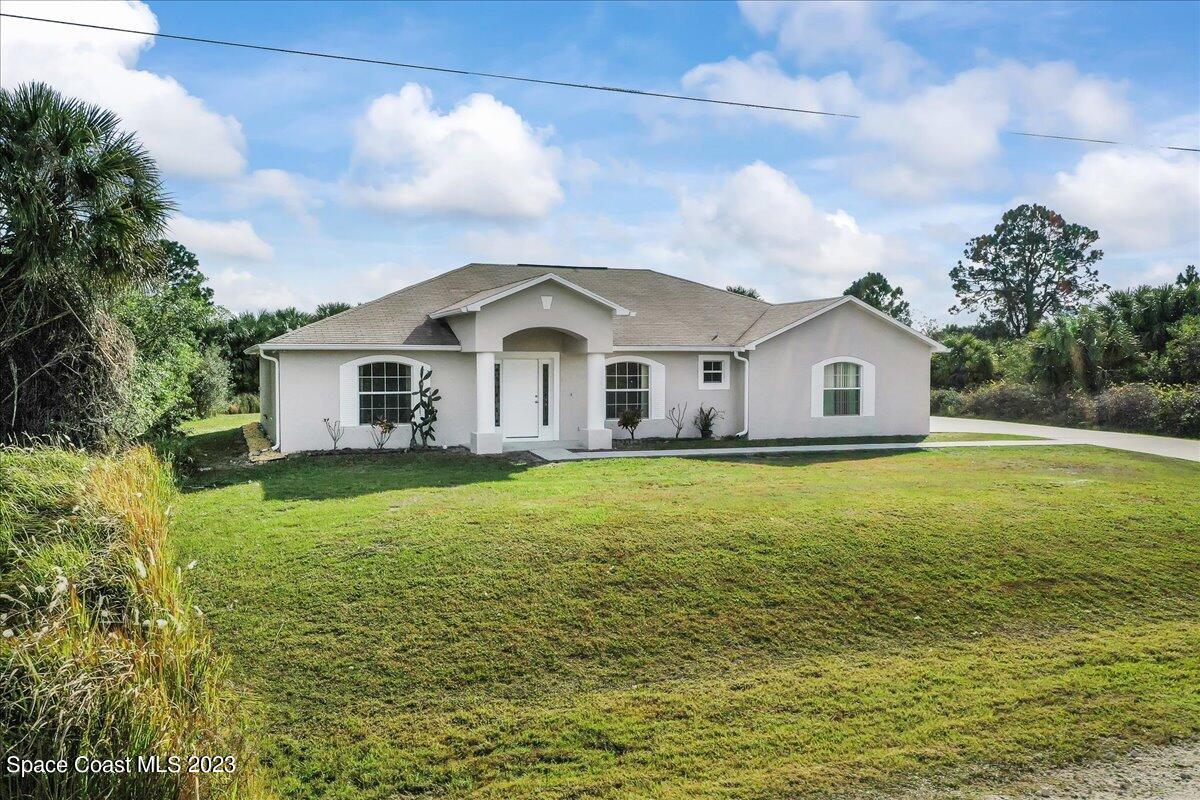 590 Fountain Street Southwest Palm Bay, FL 32908 - Photo 1 of 40 a front view of a house with garden