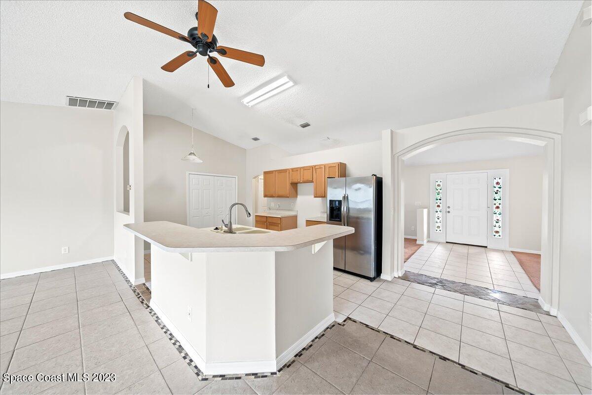 590 Fountain Street Southwest Palm Bay, FL 32908 - Photo 12 of 40 a view of kitchen with stainless steel appliances kitchen island a sink a refrigerator and a stove top oven