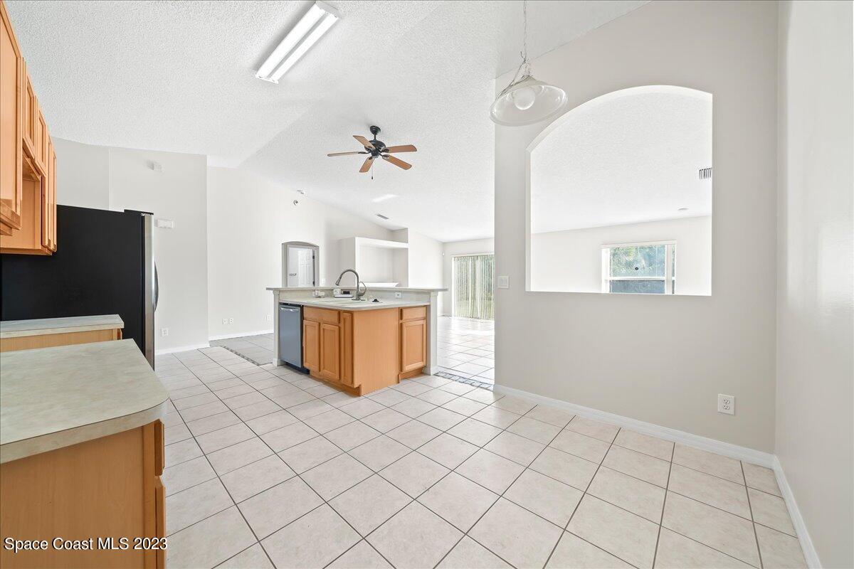 590 Fountain Street Southwest Palm Bay, FL 32908 - Photo 14 of 40 a kitchen with stainless steel appliances a refrigerator and a stove top oven