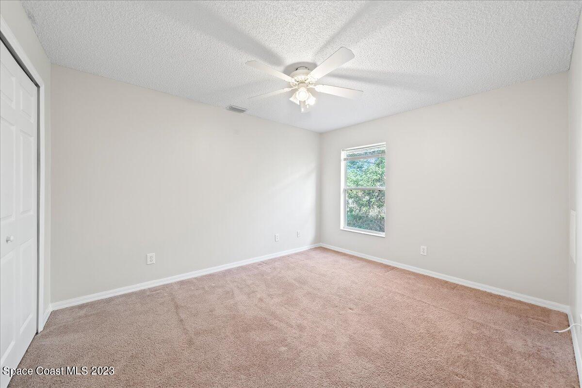 590 Fountain Street Southwest Palm Bay, FL 32908 - Photo 19 of 40 an empty room with a window and a fan