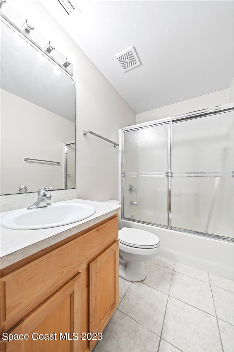 590 Fountain Street Southwest Palm Bay, FL 32908 - Photo 21 of 40 a bathroom with a granite countertop sink toilet a mirror and shower