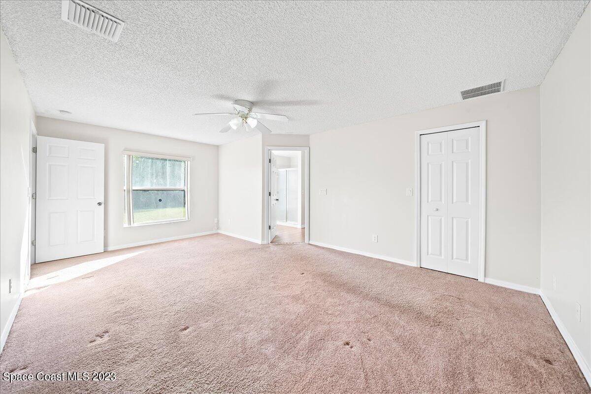 590 Fountain Street Southwest Palm Bay, FL 32908 - Photo 23 of 40 a view of an empty room with a chandelier fan