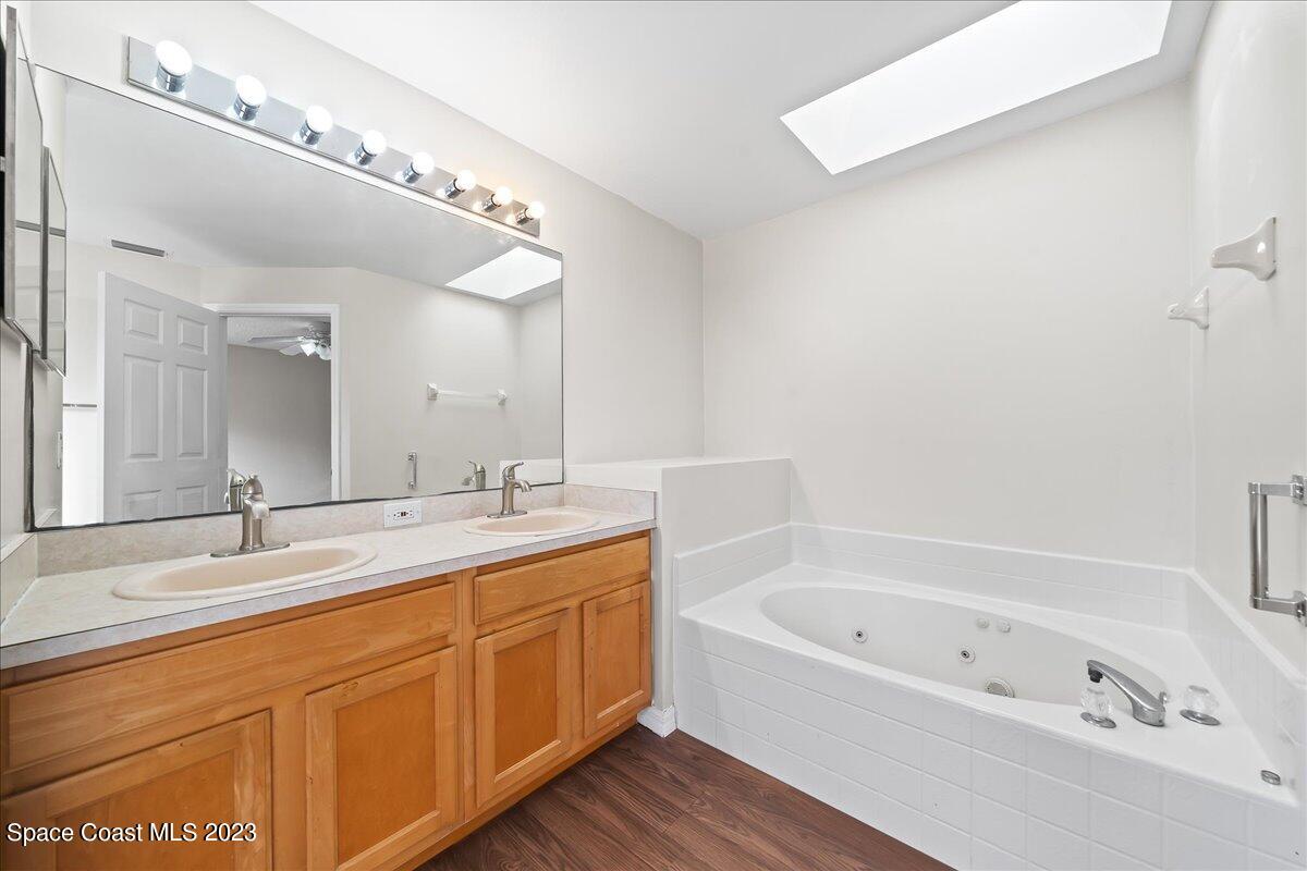 590 Fountain Street Southwest Palm Bay, FL 32908 - Photo 25 of 40 a bathroom with a bathtub a double vanity sink and mirror