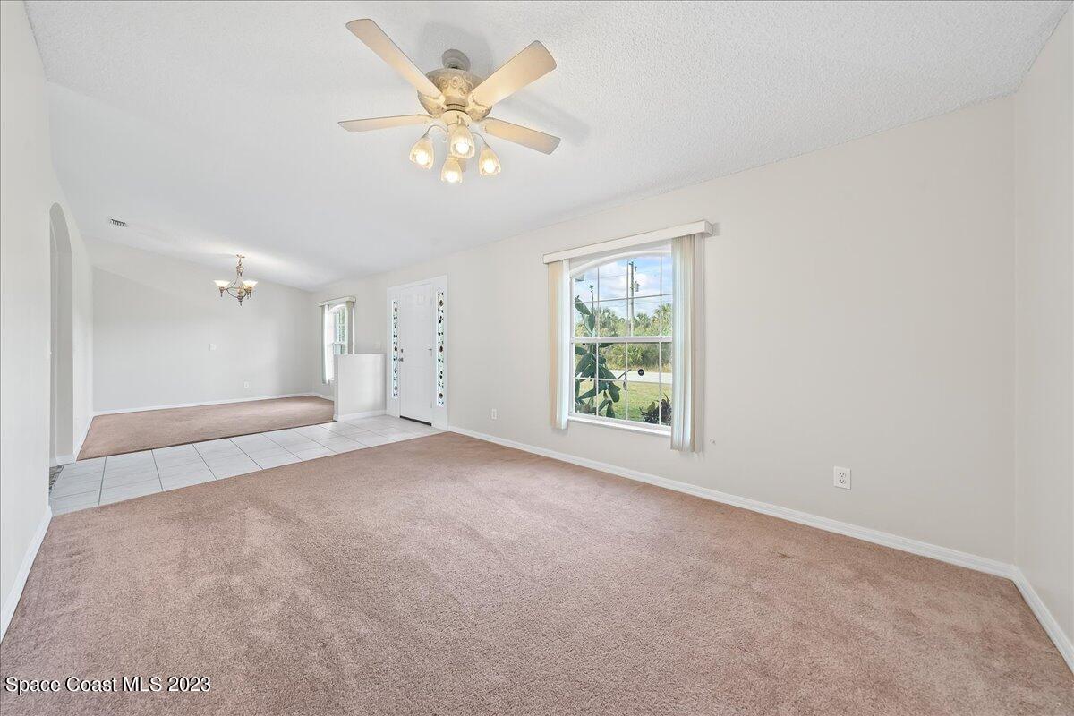590 Fountain Street Southwest Palm Bay, FL 32908 - Photo 6 of 40 an empty room with windows and fan