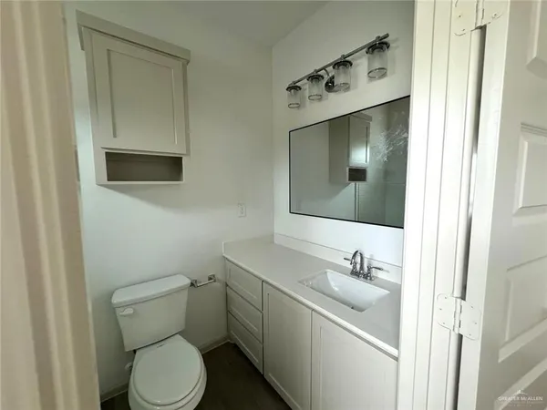 a bathroom with a toilet sink and mirror