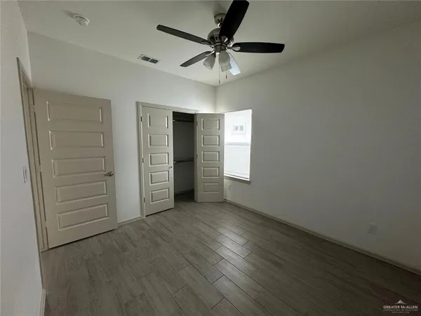 an empty room with closet and windows