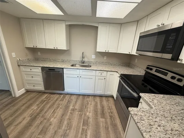 a kitchen with a sink a stove and cabinets