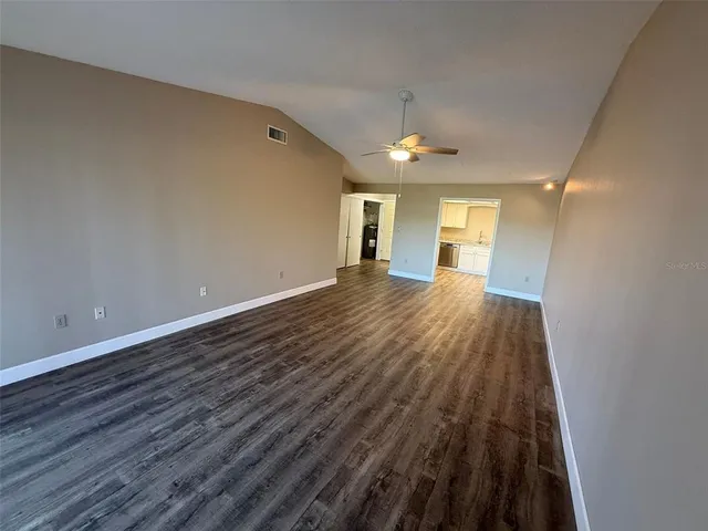 a view of a big room with wooden floor and windows