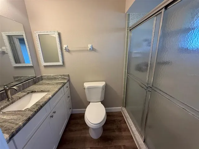 a bathroom with a granite countertop toilet sink and a mirror
