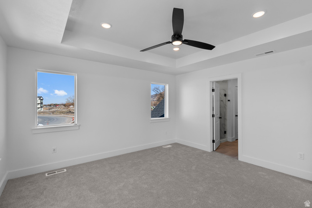 248 West 2920th Street South Logan, UT 84321 - Photo 28 of 47 Tray ceiling with recessed lighting, modern ceiling fan, gray carpet flooring, white walls, and bright windows