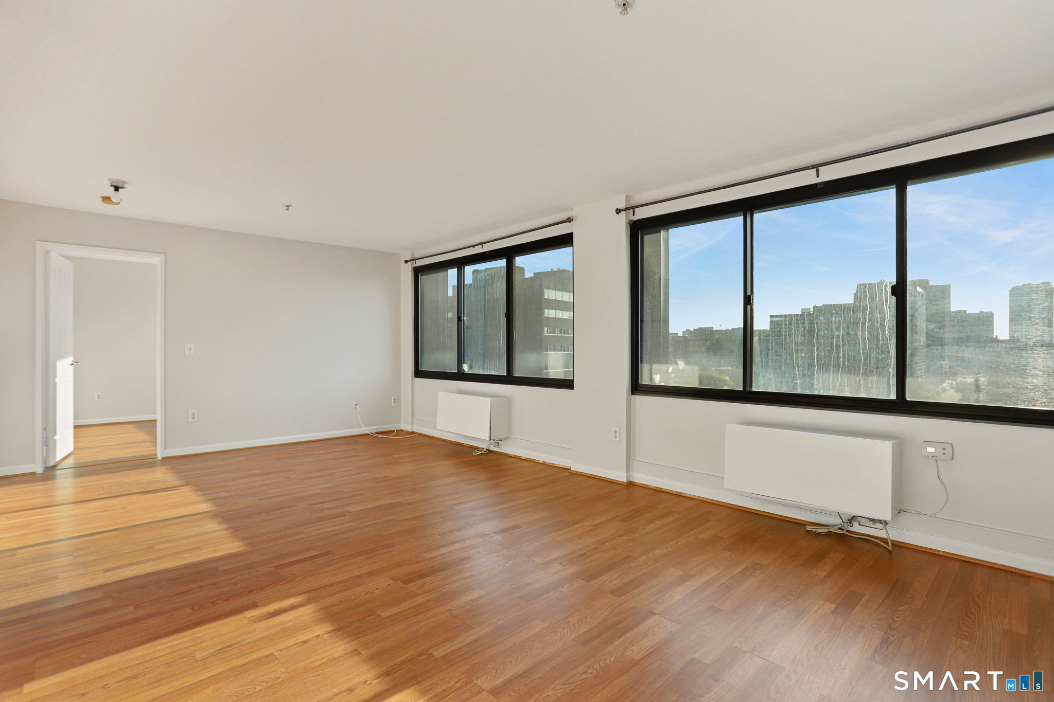 300 Broad Street, Unit 603 Stamford, CT 06901 - Photo 13 of 20 a view of an empty room with wooden floor and a window