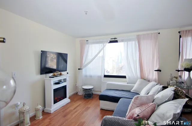 a living room with furniture a flat screen tv and a fireplace