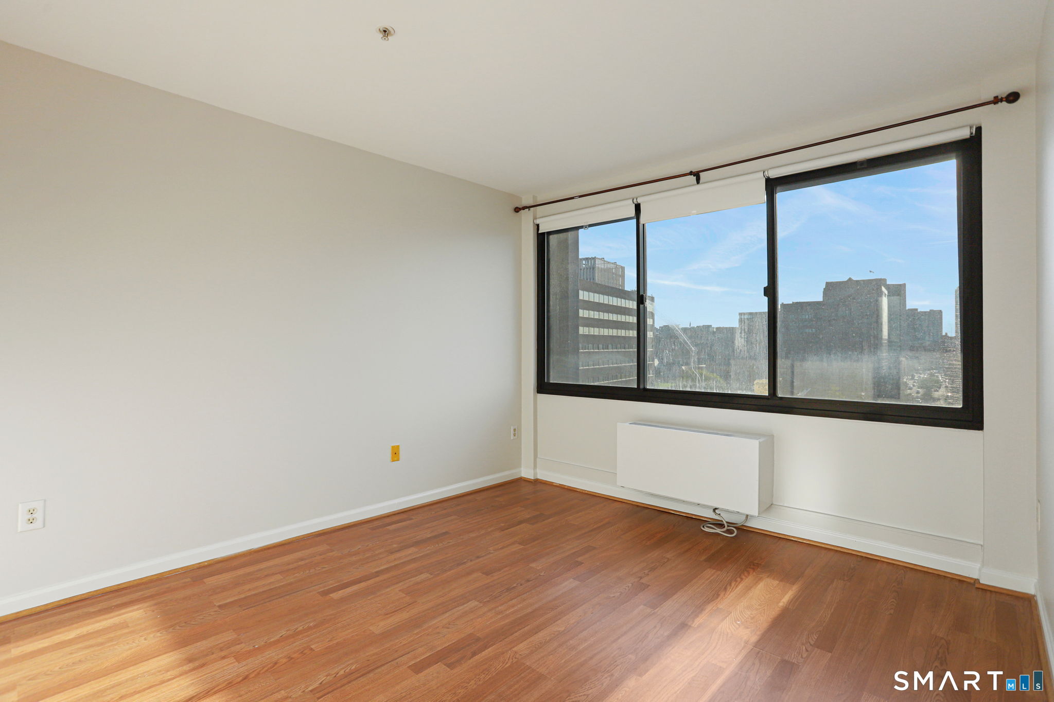 300 Broad Street, Unit 603 Stamford, CT 06901 - Photo 15 of 20 a view of an empty room with wooden floor and a window
