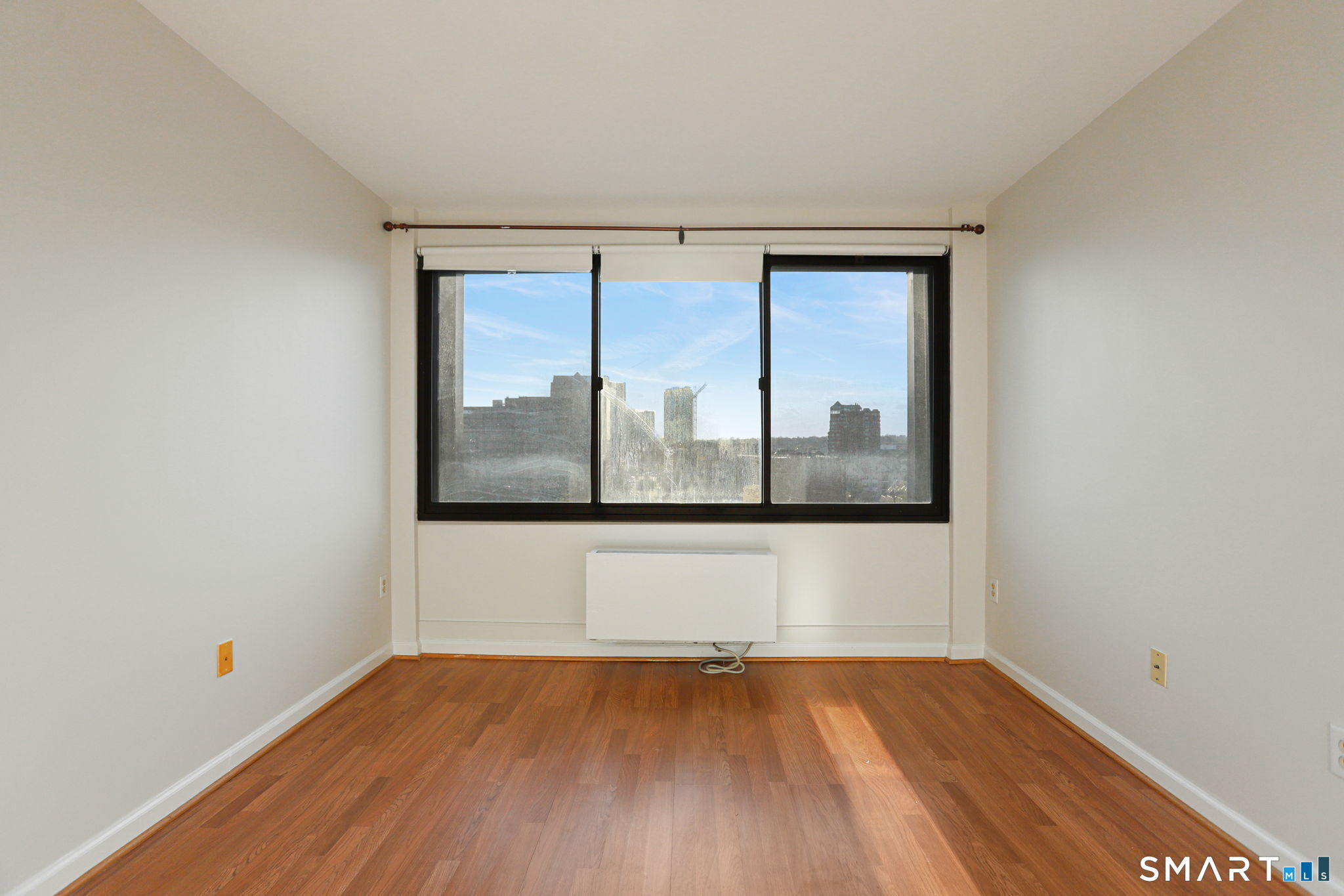 300 Broad Street, Unit 603 Stamford, CT 06901 - Photo 16 of 20 a view of an empty room with wooden floor and a window