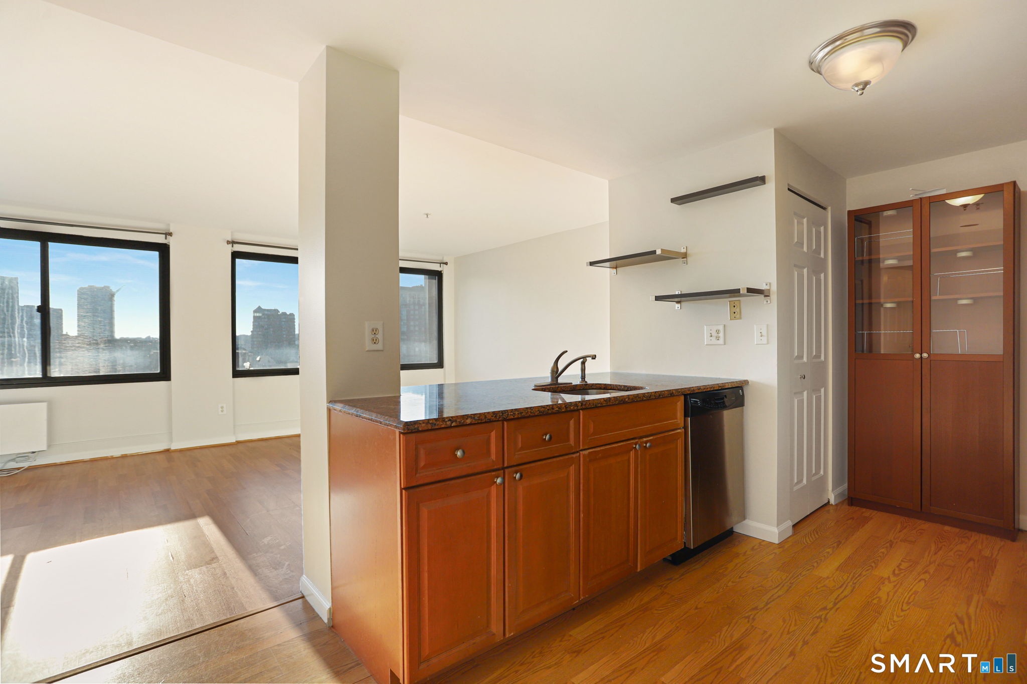 300 Broad Street, Unit 603 Stamford, CT 06901 - Photo 2 of 20 a kitchen with stainless steel appliances granite countertop a sink and wooden cabinets