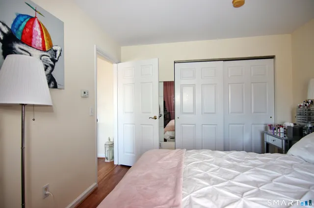 a bedroom with a bed and a painting on the wall