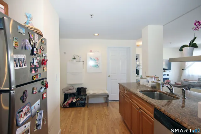a kitchen that has a sink and a stove with wooden floor