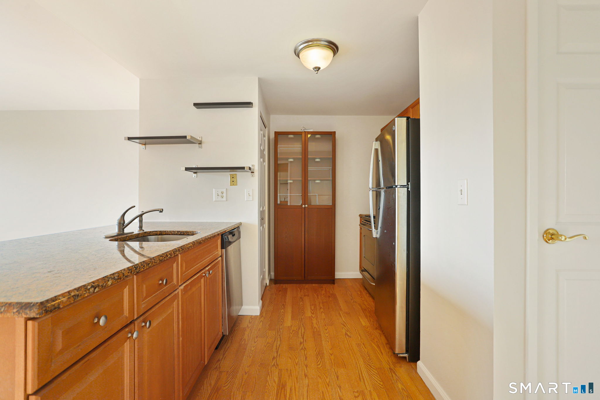 300 Broad Street, Unit 603 Stamford, CT 06901 - Photo 3 of 20 a kitchen with granite countertop a sink and refrigerator