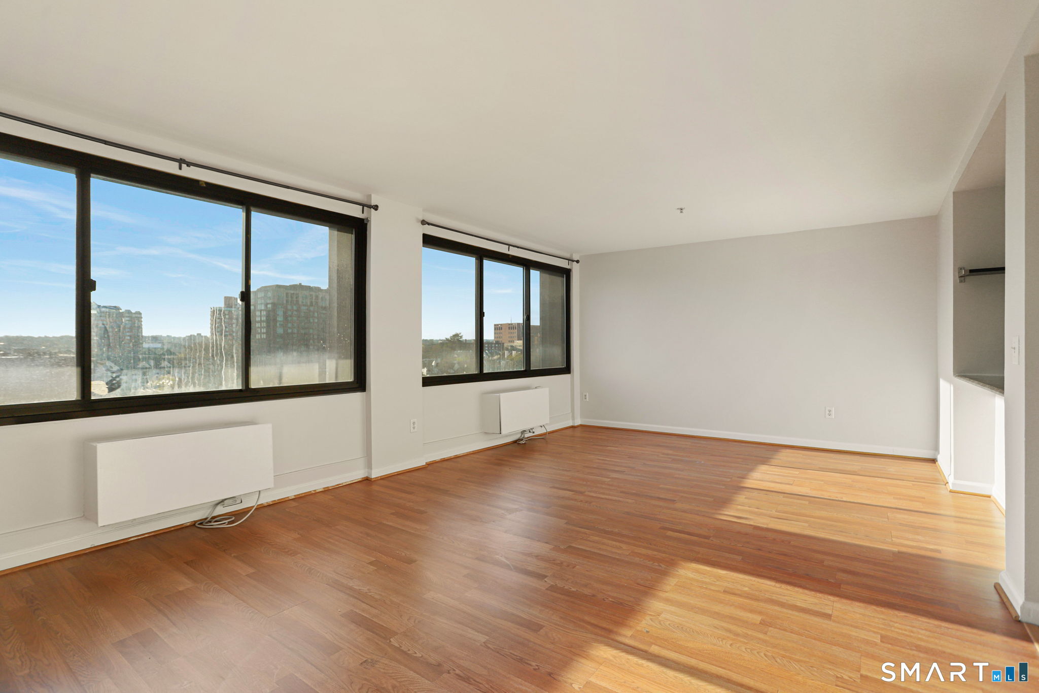 300 Broad Street, Unit 603 Stamford, CT 06901 - Photo 10 of 20 a view of an empty room with a window and wooden floor
