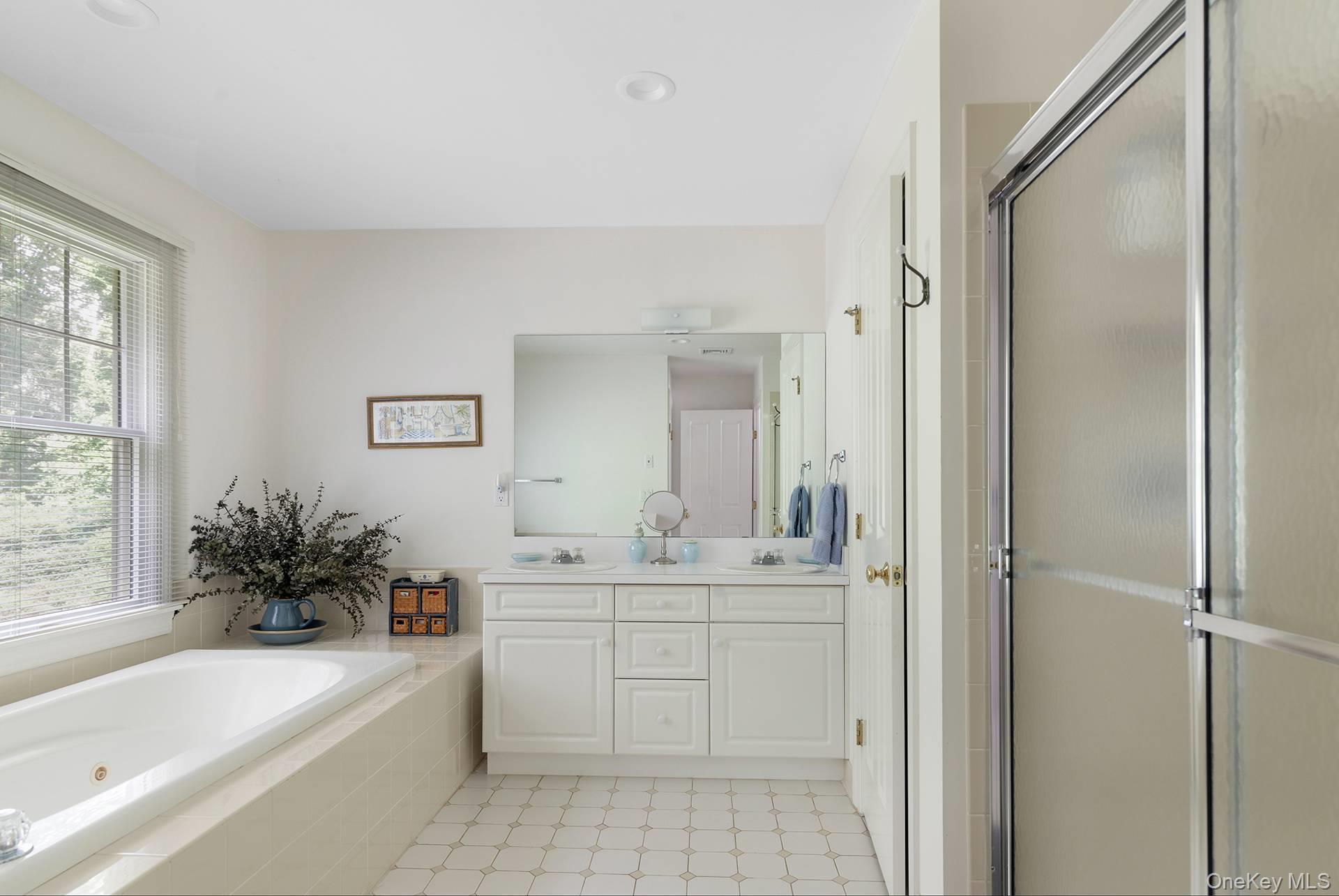 20 Cutter Court East Hampton, NY 11937 - Photo 11 of 18 a bathroom with a bathtub a sink a window and a mirror