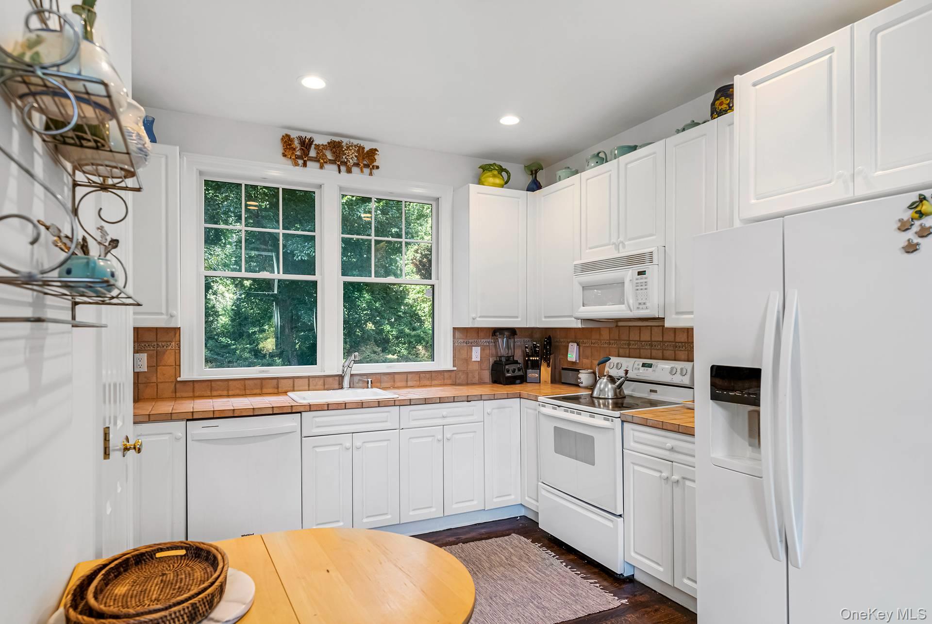 20 Cutter Court East Hampton, NY 11937 - Photo 8 of 18 a kitchen with white cabinets and window
