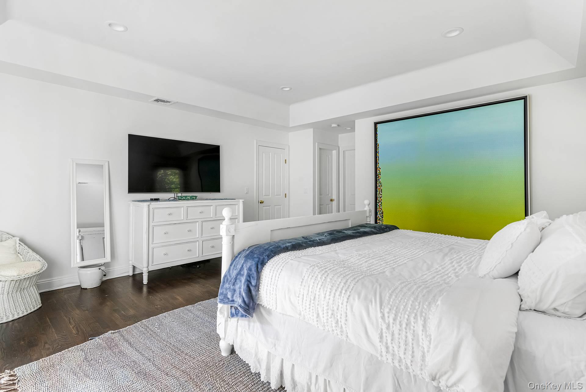 20 Cutter Court East Hampton, NY 11937 - Photo 10 of 18 a spacious bedroom with a bed and a flat screen tv