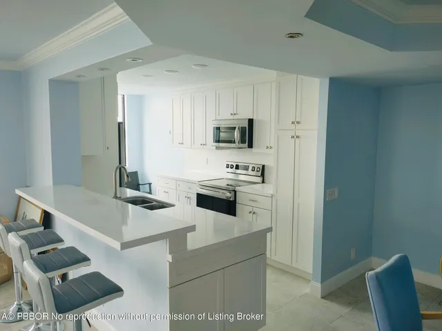 a kitchen with stainless steel appliances white cabinets a stove top oven a sink and dishwasher