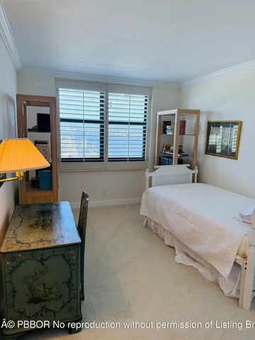 a bedroom with a bed a dresser and next to a window