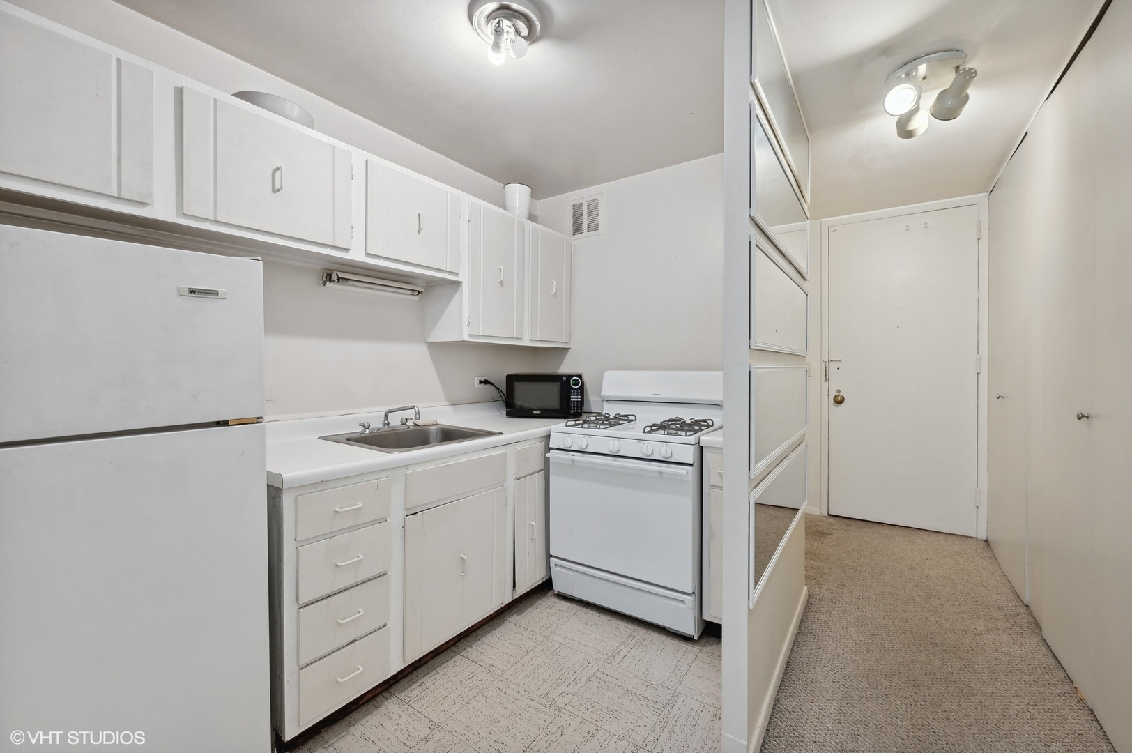 1 East Scott Street, Unit 601 Chicago, IL 60610 - Photo 7 of 15 a kitchen with white cabinets and white appliances