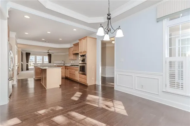 a view of a kitchen with granite countertop stainless steel appliances and a chandelier