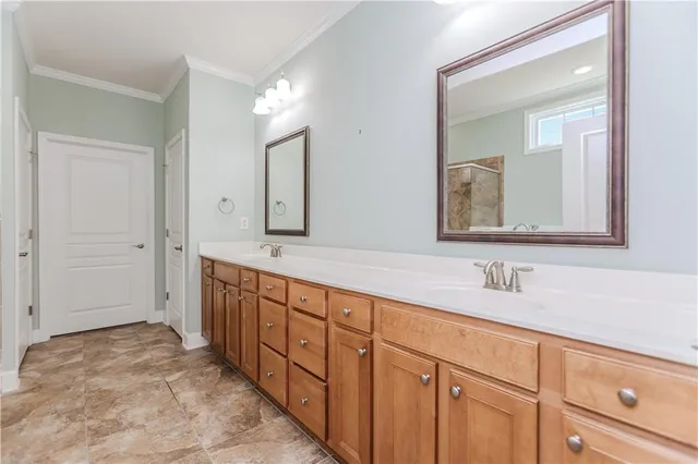 a en suite bathroom with double sink large mirror and