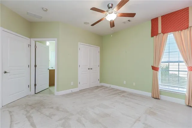 an empty room with a ceiling fan and a window