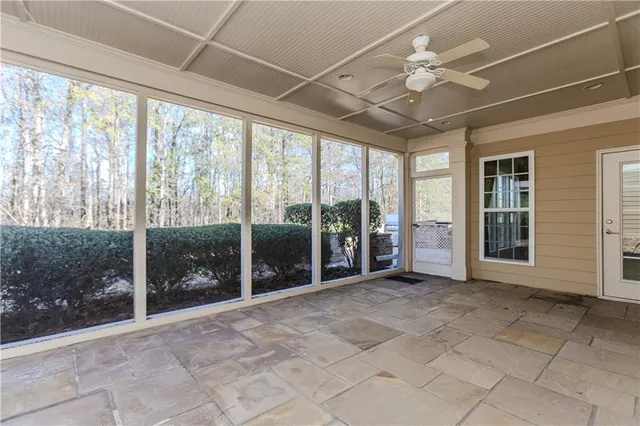 a view of a white house next to a yard with large trees