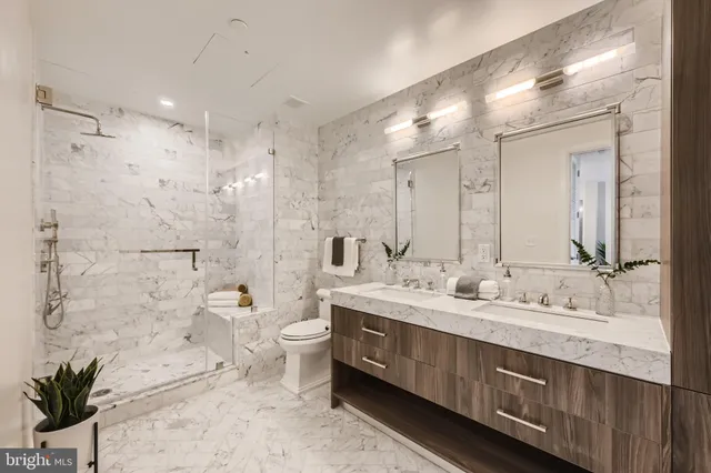 a spacious bathroom with a double vanity sink toilet and shower