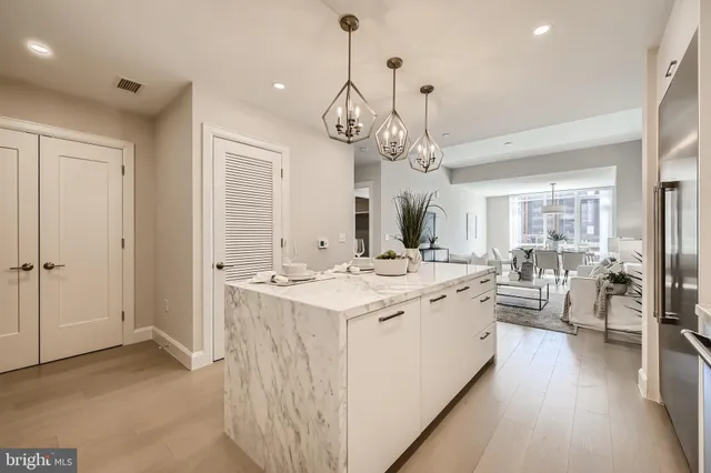 a large kitchen with kitchen island a large counter space a sink appliances and living room view