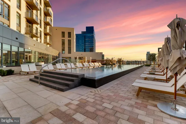 a swimming pool with outdoor seating and buildings