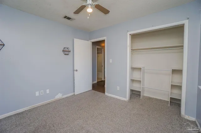 an empty room with closet and a hallway
