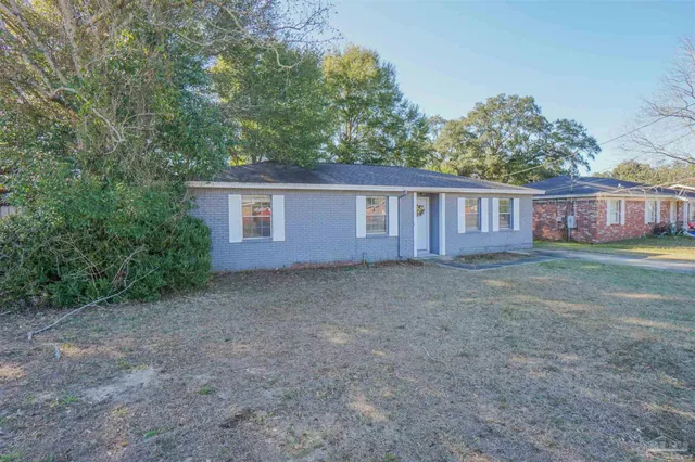a view of a house with backyard and trees