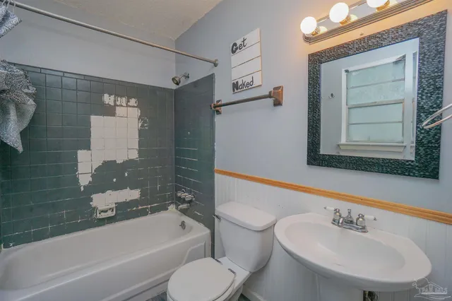 a bathroom with a bathtub shower sink vanity and toilet
