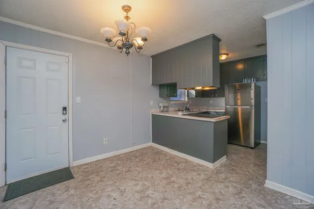 a room with kitchen island stainless steel appliances a sink and cabinets