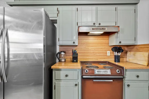 a kitchen with stainless steel appliances granite countertop a refrigerator and a stove