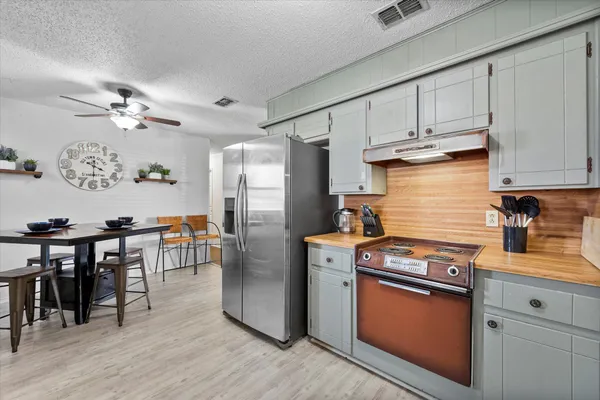 a kitchen with stainless steel appliances granite countertop a stove refrigerator and cabinets