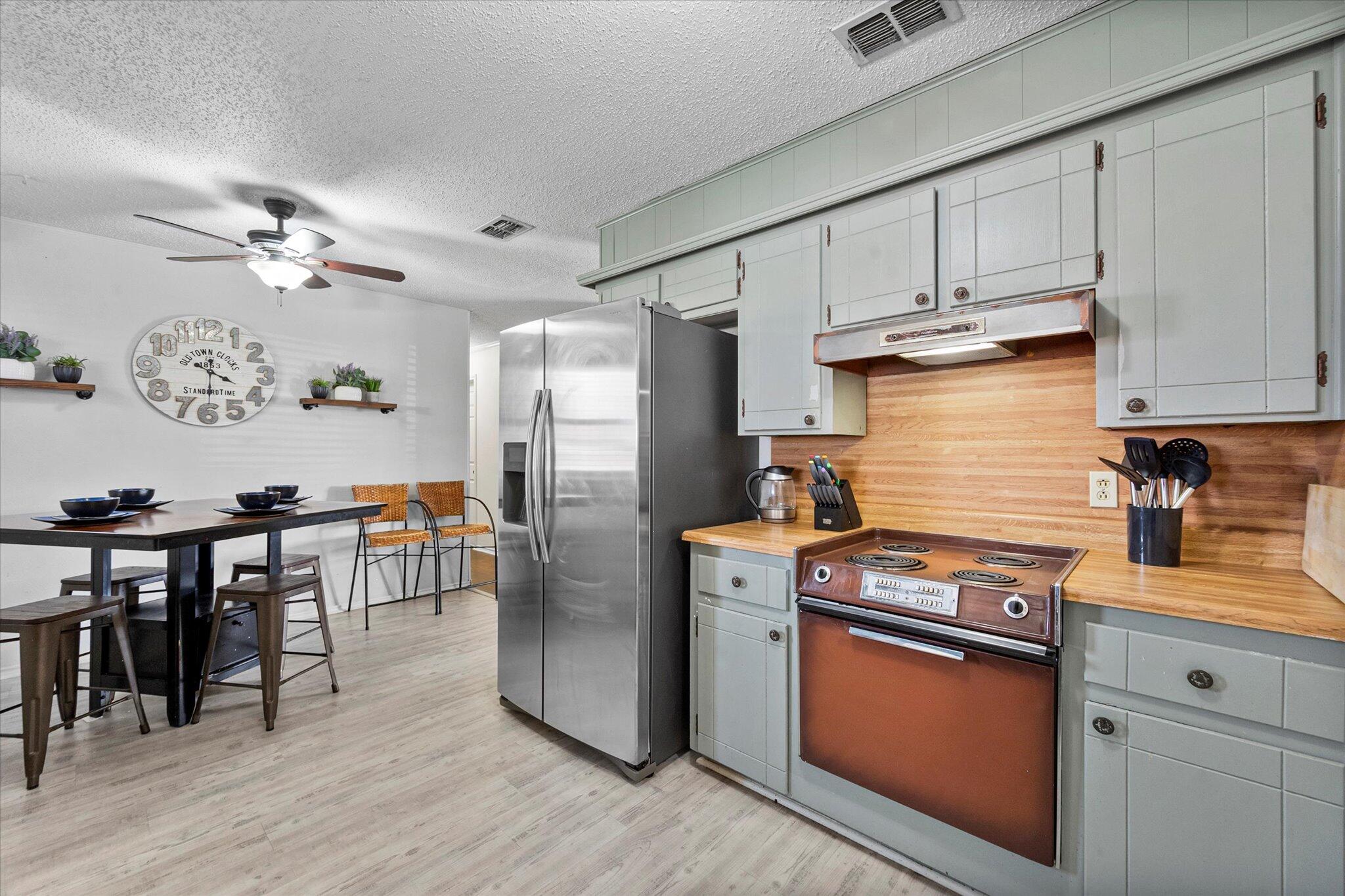 4824 8th Street Lubbock, TX 79416 - Photo 15 of 27 a kitchen with stainless steel appliances granite countertop a stove refrigerator and cabinets