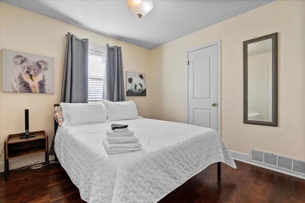 a bedroom with a bed and wooden floor