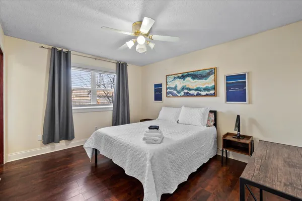 a bedroom with a bed and a table in it with wooden floor
