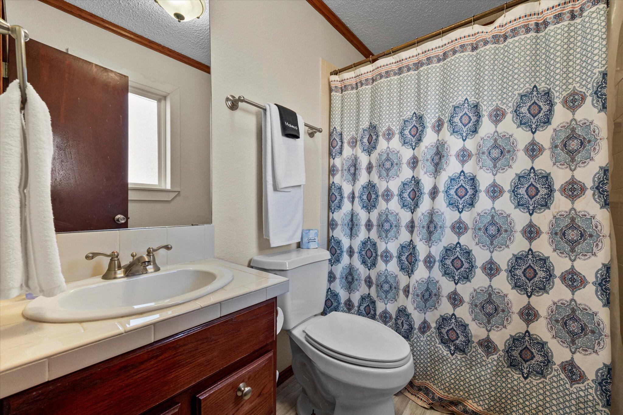 4824 8th Street Lubbock, TX 79416 - Photo 24 of 27 a bathroom with a sink and a mirror