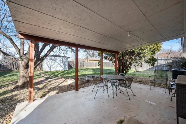 a view of a patio with a table chairs and a backyard