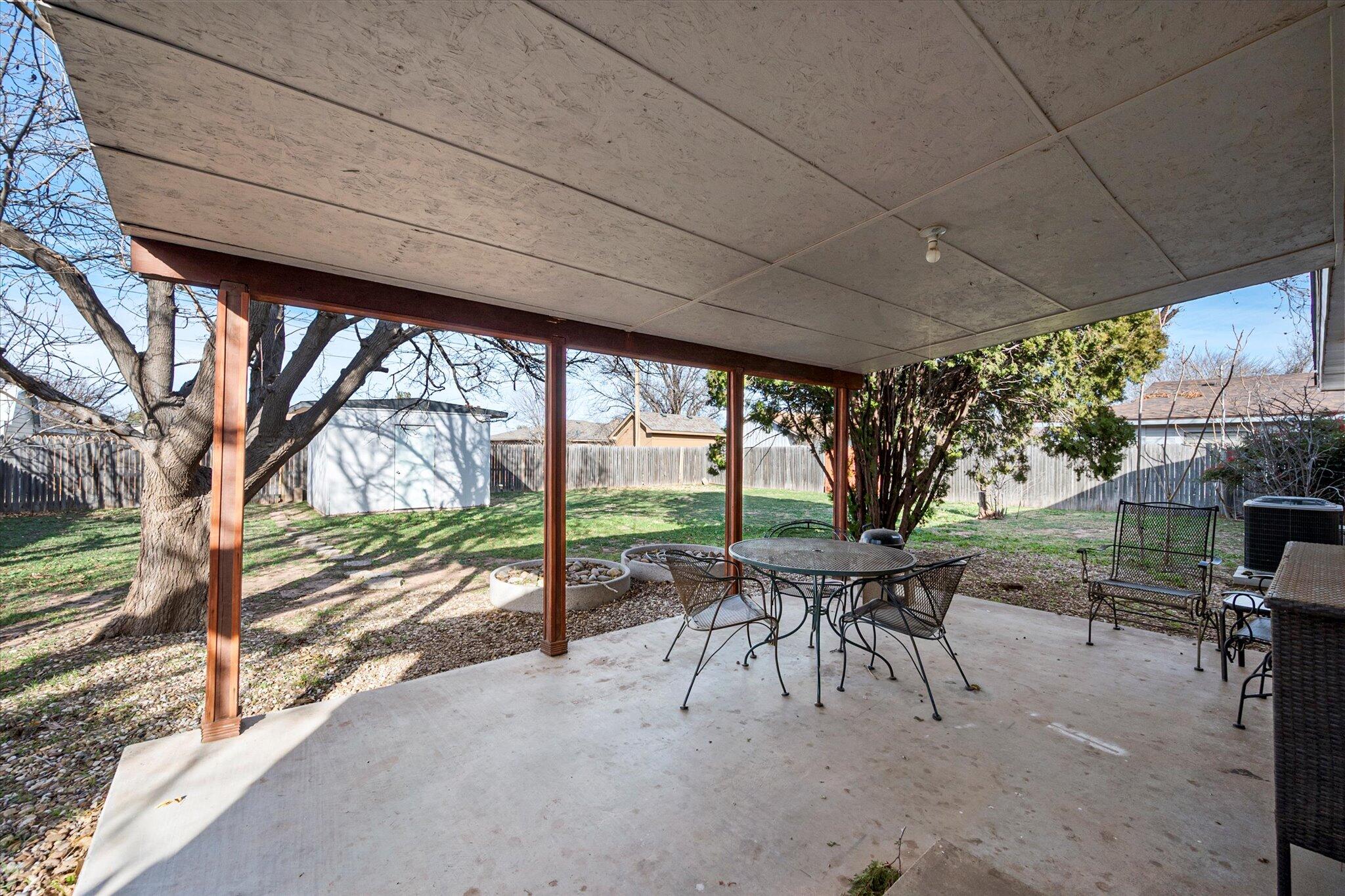 4824 8th Street Lubbock, TX 79416 - Photo 25 of 27 a view of a patio with a table chairs and a backyard