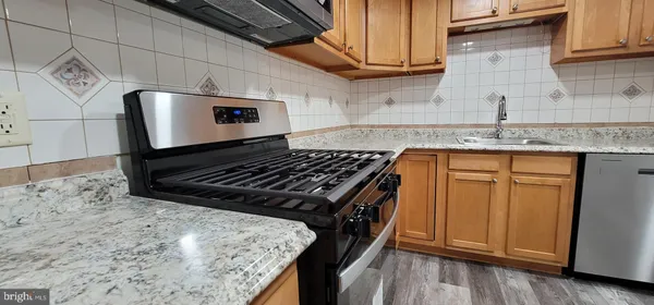a kitchen with granite countertop a stove and a wooden cabinets