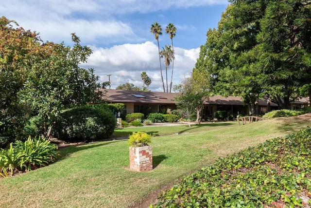 a front view of a house with a garden